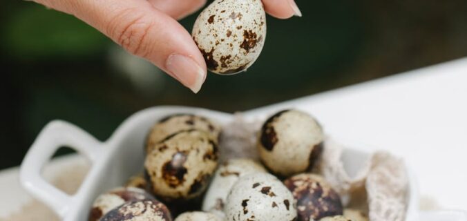 woman with spotty quail eggs in ceramic pan